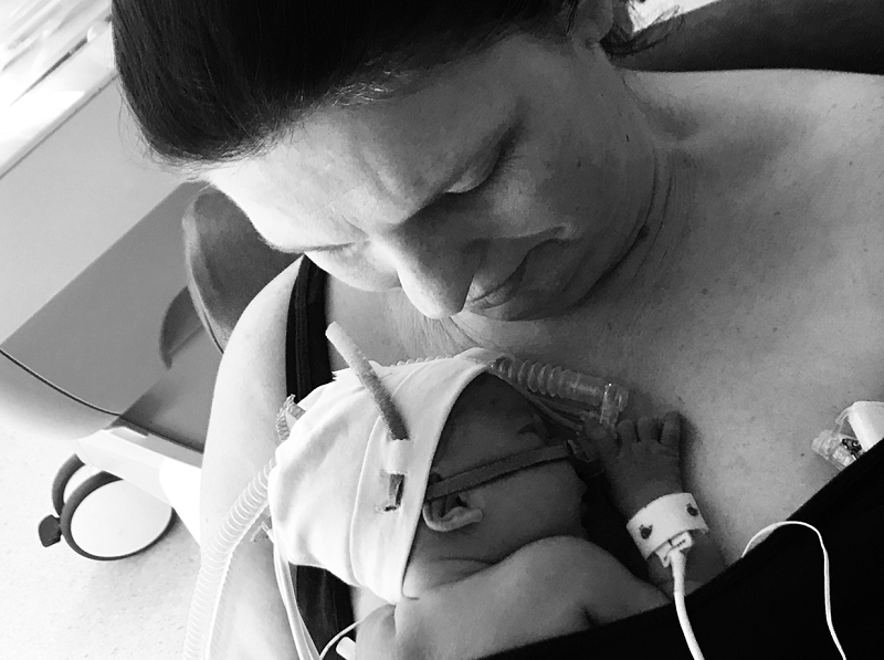 Geriatric mum Amy holding newborn premature baby Sidney