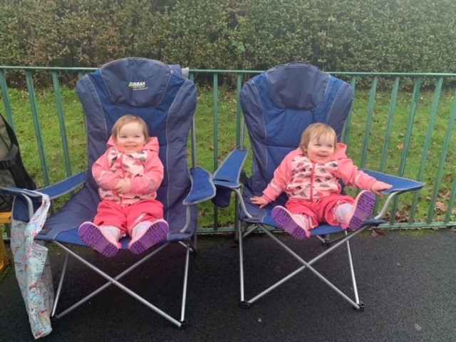 Twin girls sitting deckchairs in the garden