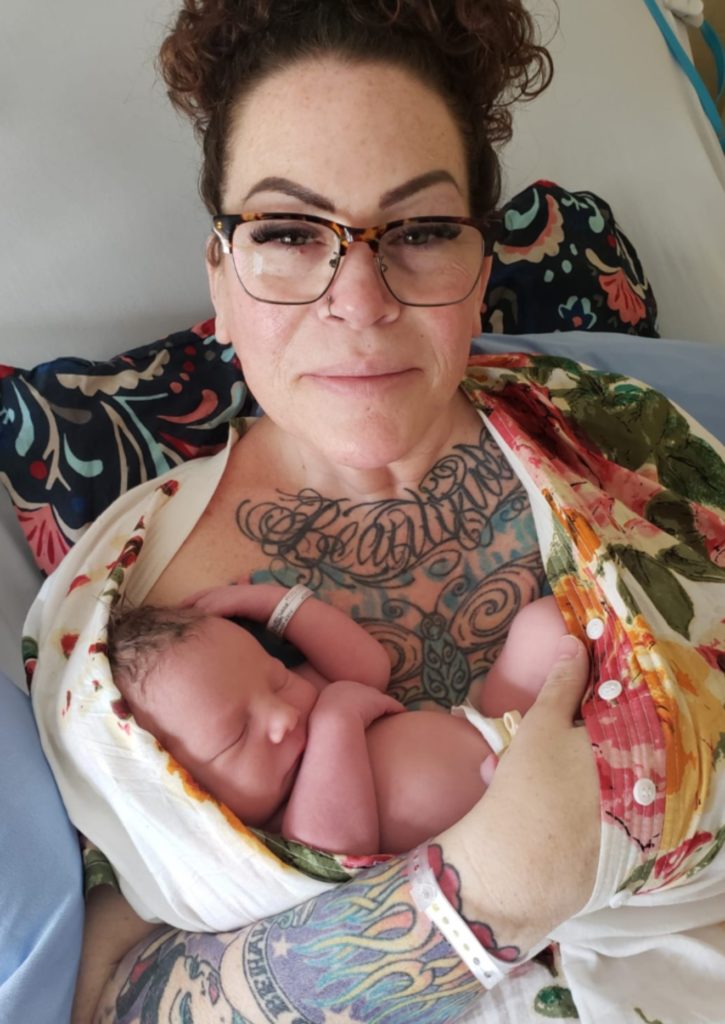 geriatric mum cradling her newborn baby