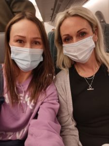 Lucy Baker aher sister Emily on an plane to Hong Kong with facial masks on